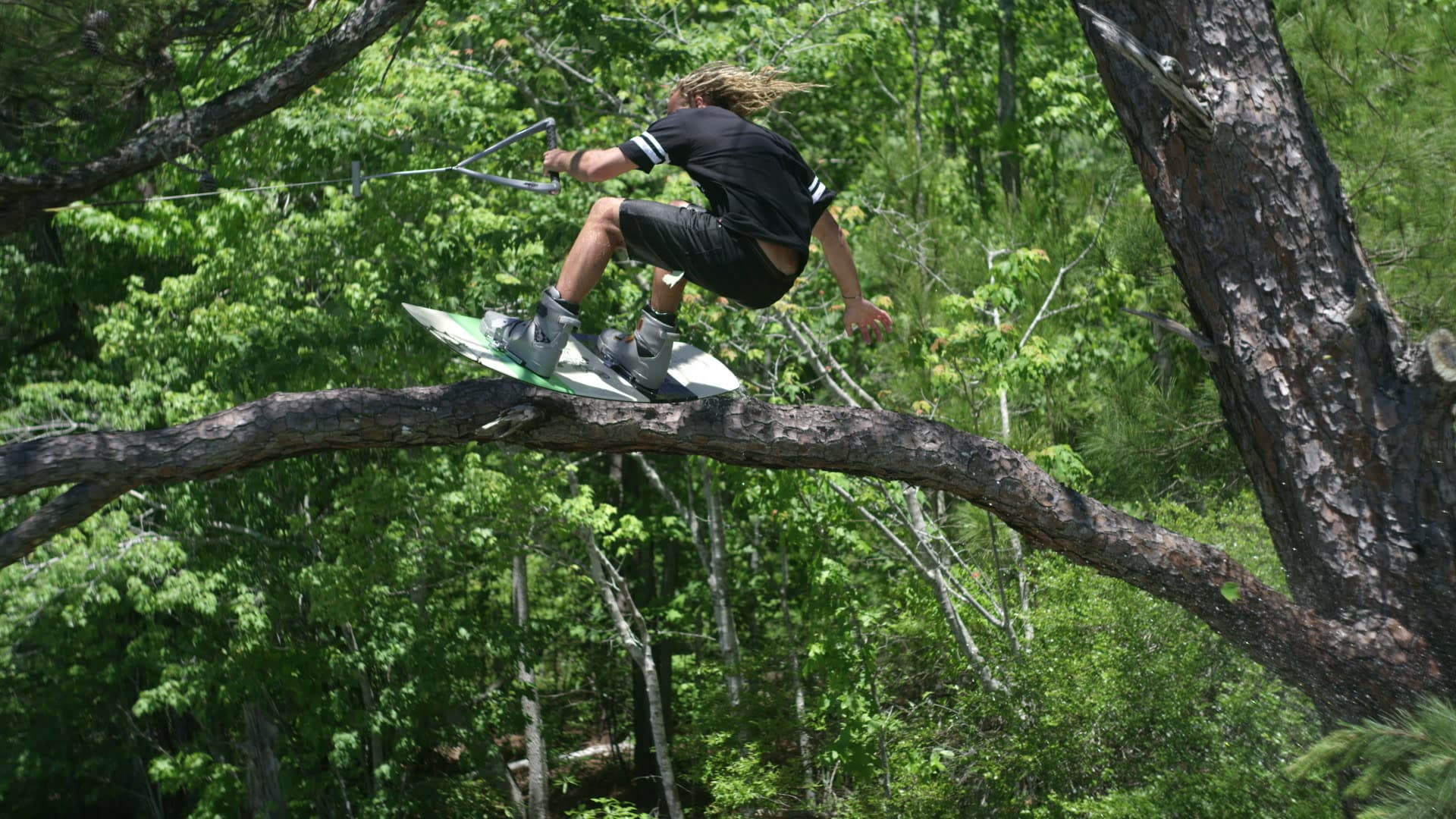 Wakeboarder throwing a tree grab over the water