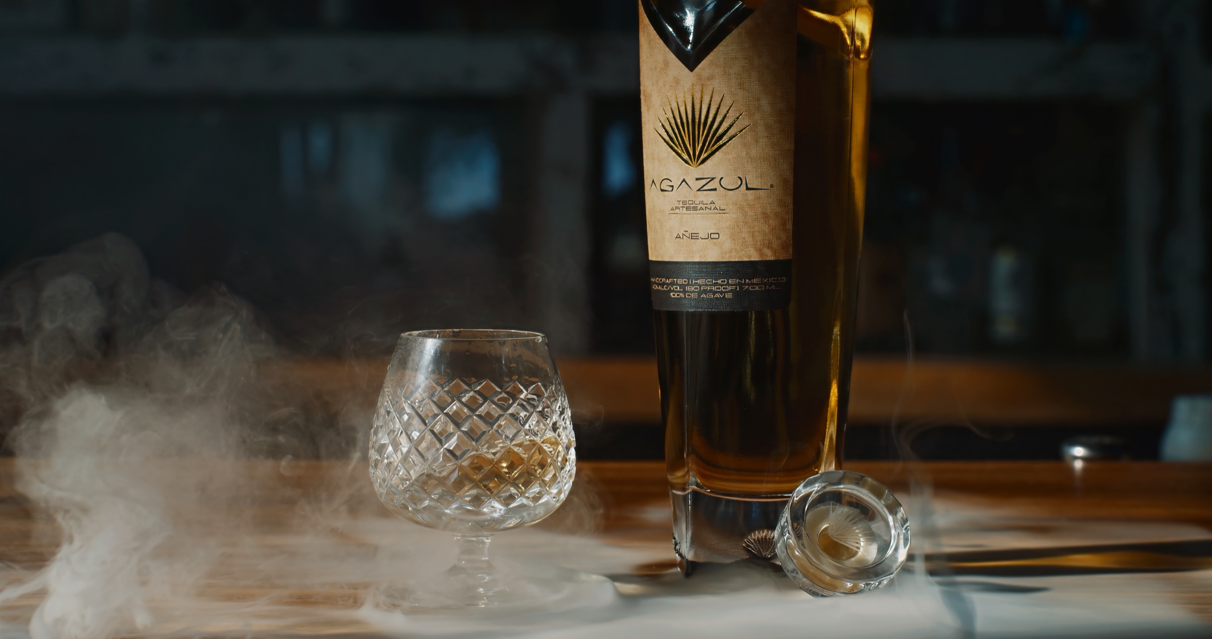 Agazul Tequila bottle and crystal glass with bar haze