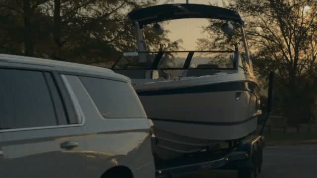 Chevrolet Suburban towing a boat at dusk