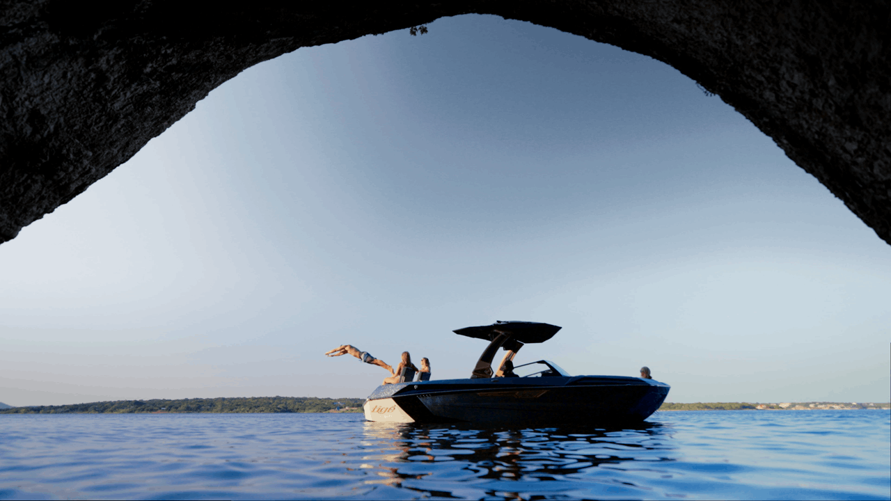 Athlete diving off Tige boat into lake water