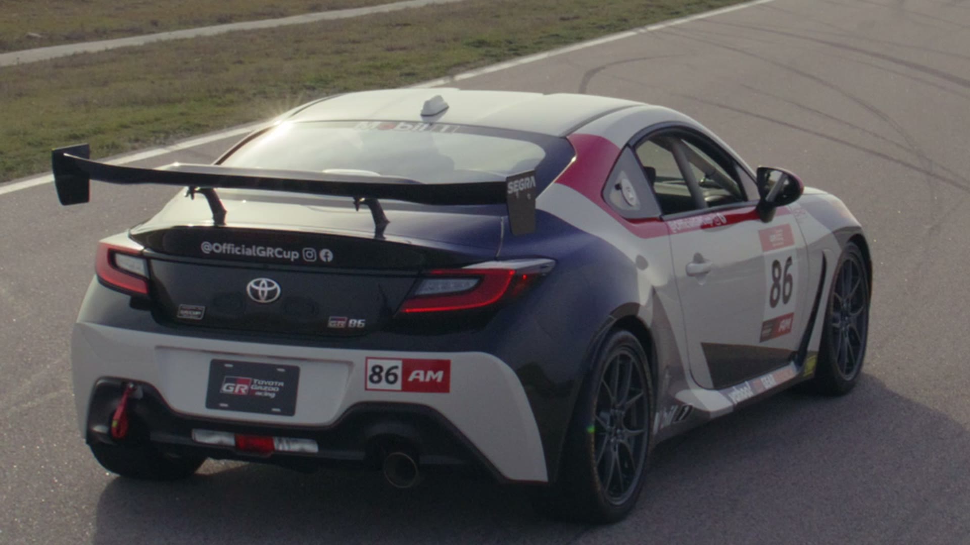 Toyota GR86 on a racetrack, rear three-quarter