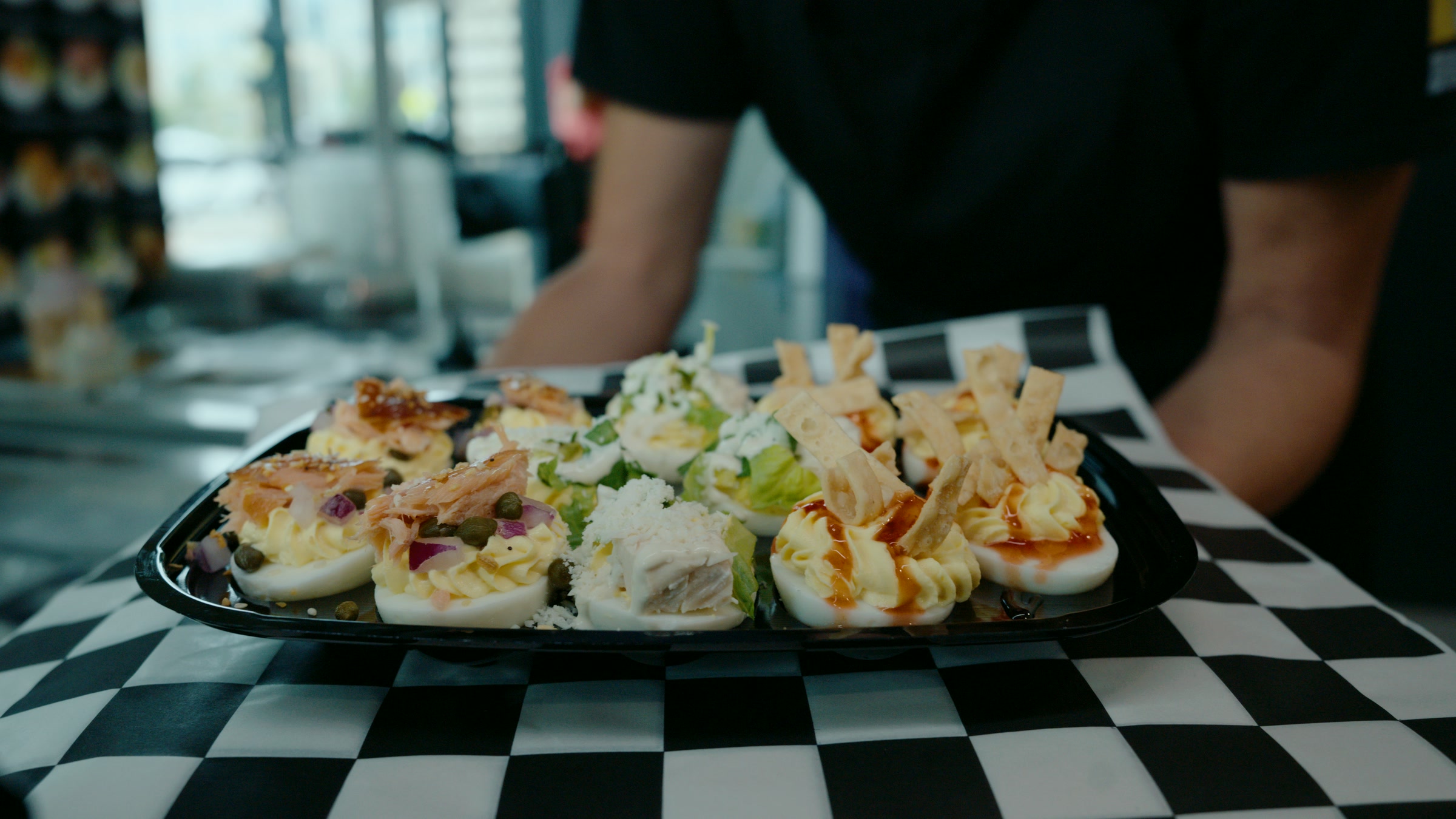 Service frame of a deviled egg platter on a checkerboard table setting.