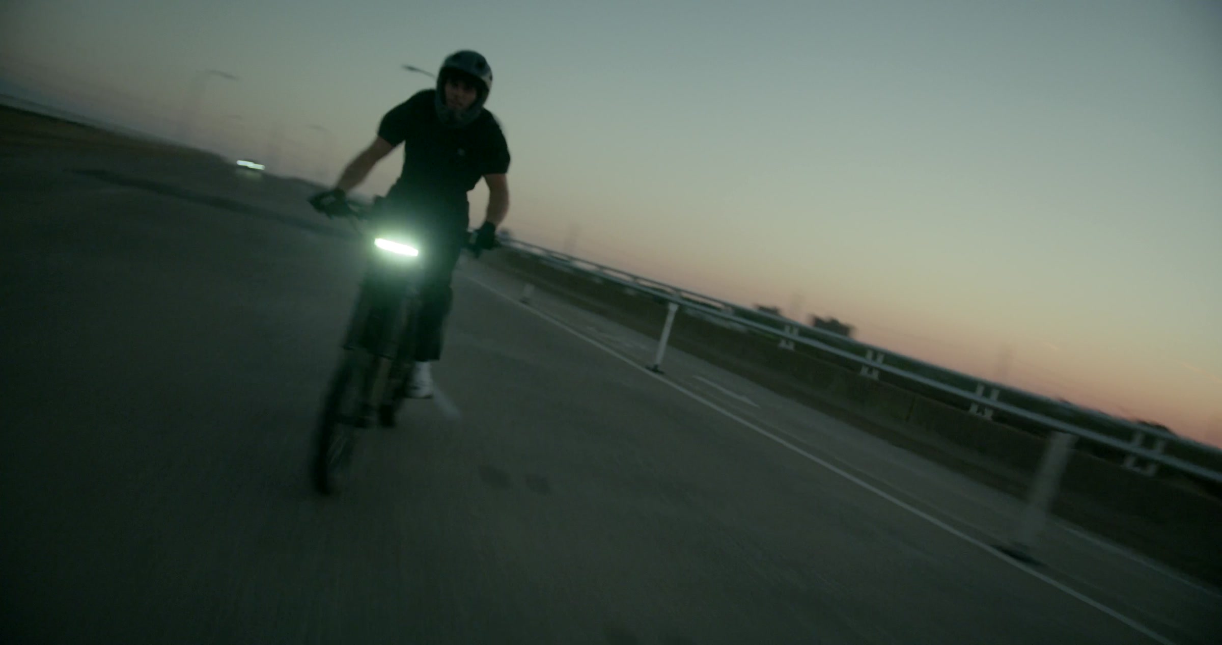 Still frame titled "Dusk Road Headlight Ride" from the Filmsupply Factory Bike TV Construction Selects source drop.