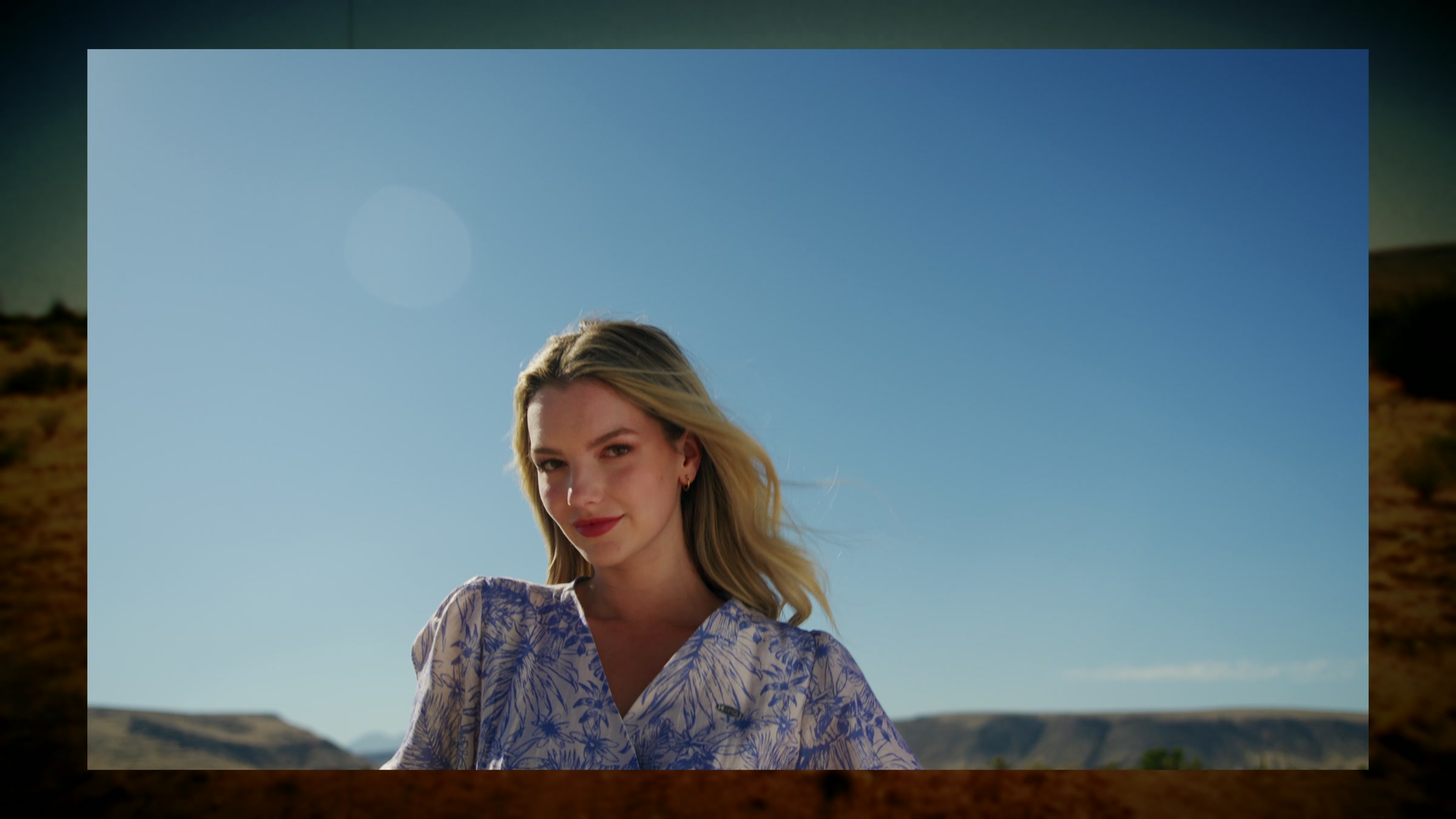 Blonde desert fashion portrait against clean landscape and bright sun.