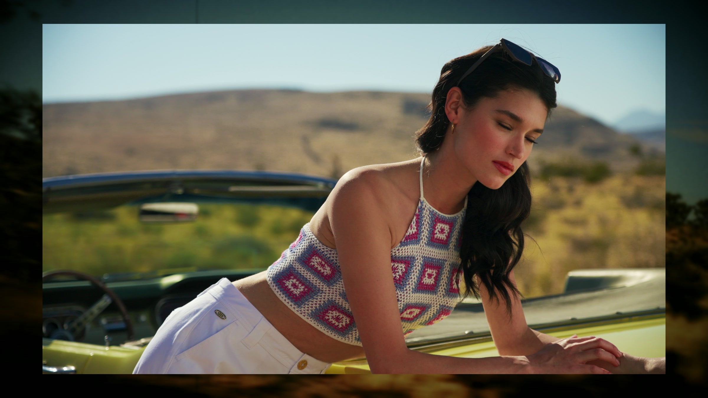 Desert fashion portrait with pink knit wardrobe, clean sky, and direct sun.