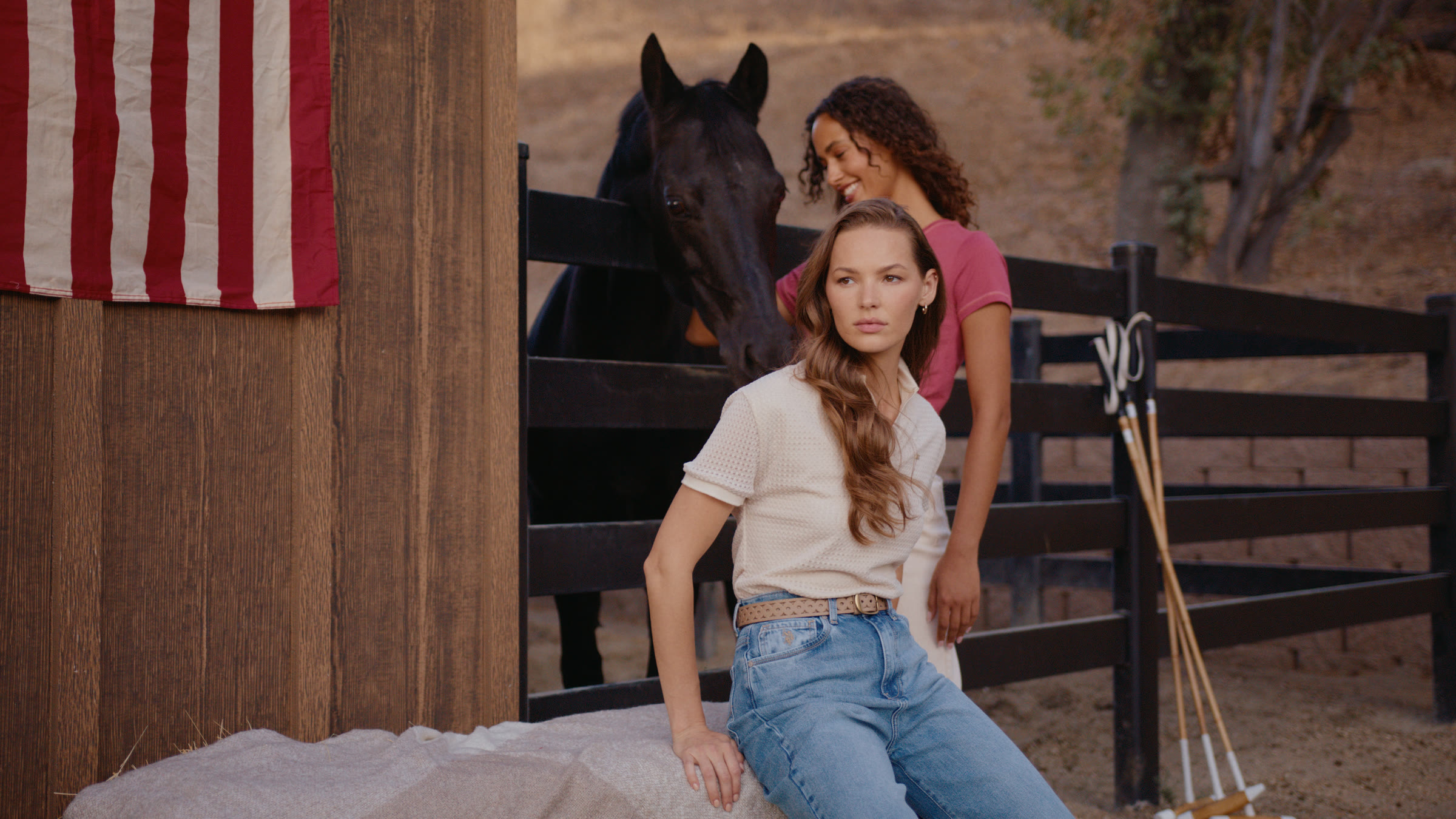 Stable fashion frame with two models, horse, and American flag background texture.