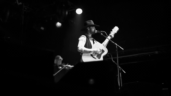 Looping black and white stage performance frame with spotlight and performer silhouette.